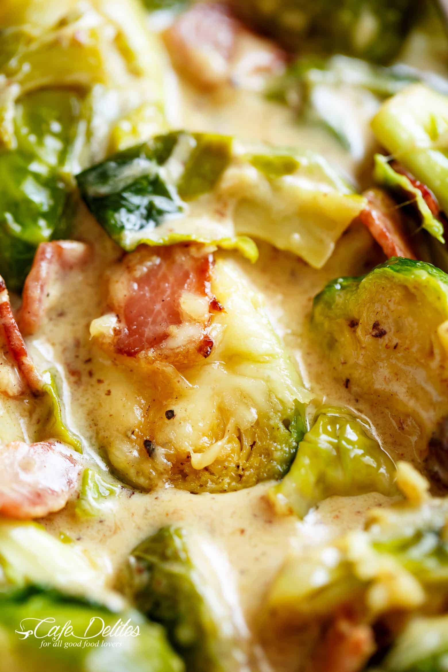 A close up of Brussel Sprouts in a cheesy cream sauce with crispy bacon pieces.