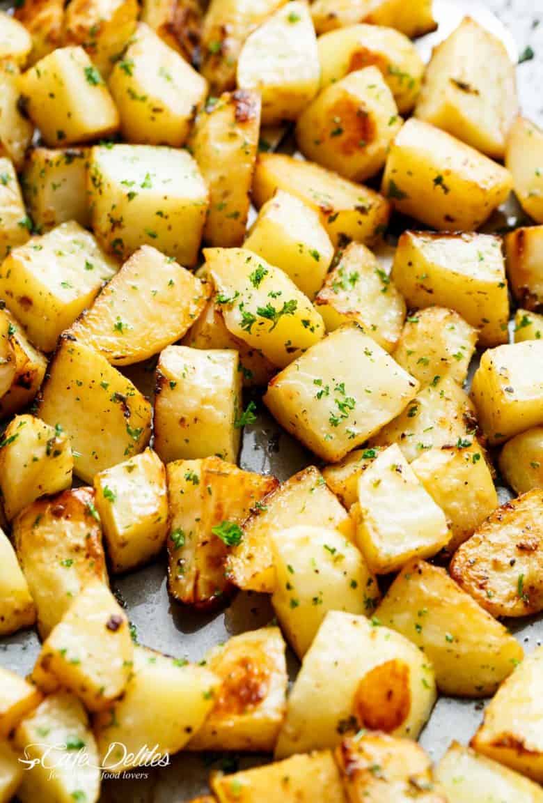 Crispy Garlic Roasted Potatoes are a super simple side dish perfect with anything! Buttery, garlicky, fluffy inside and and crispy edges. These potatoes tick all my boxes! No need for bowls or pans when you can prepare AND cook your potatoes on ONE PAN! | cafedelites.com