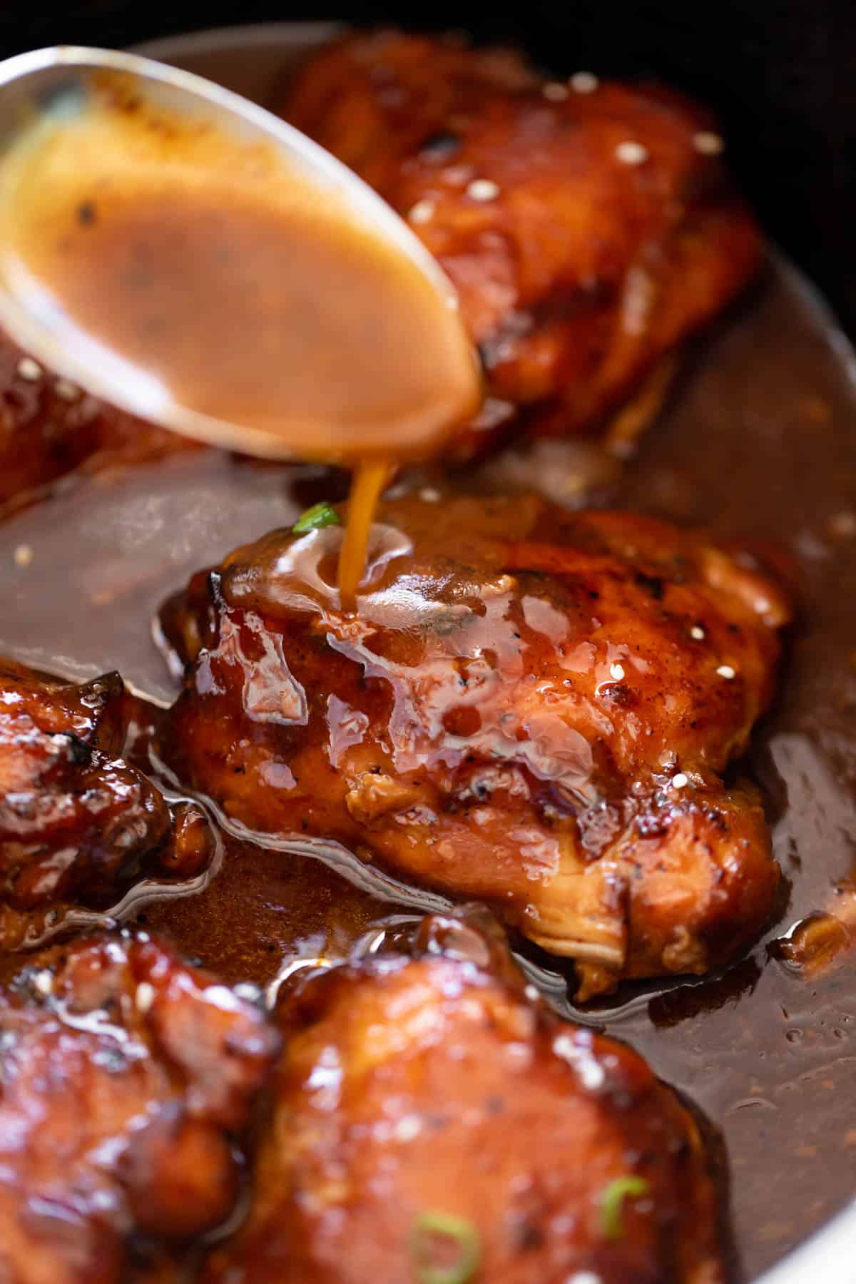 Slow Cooker Honey Garlic Chicken drizzled with honey garlic sauce in a slow cooker bowl | cafedelites.com