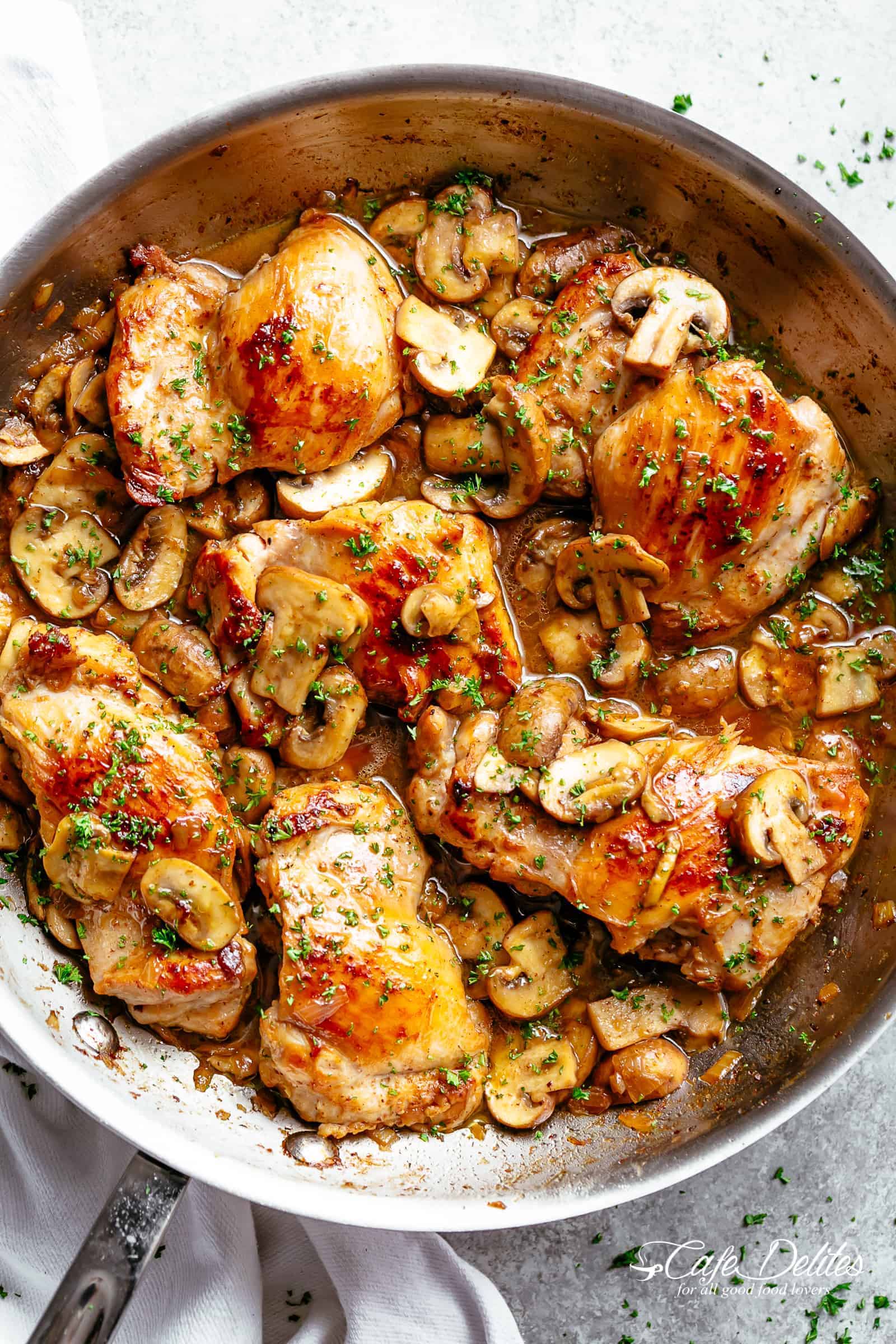 Golden seared Garlic Mushroom Chicken Thighs in a delicious, buttery sauce with a sprinkle of herbs | cafedelites.com