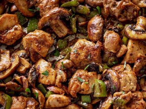 Garlic Mushroom Chicken Bites cook in no time at all! An easy dinner recipe cooked in a silver pan or skillet with a wooden spoon. | cafedelites.com